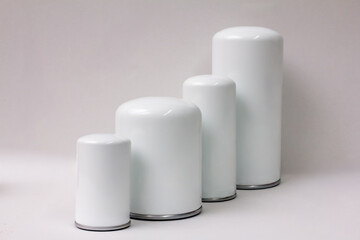 White cylindrical metal canisters in graduated sizes on plain background, ideal for product packaging mockups or ecommerce catalog layout — clean minimal design for branding and retail presentation.