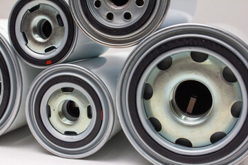 Several white spin-on oil filters arranged horizontally on neutral background, ideal for automotive maintenance catalog or engine-parts ecommerce presentation as clean product display.