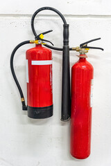 Naklejka premium two fire extinguishers of different sizes and for different types of fire in industrial installations.
