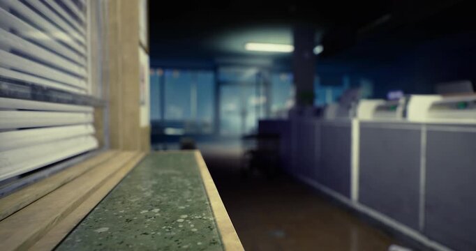 A quiet workspace is captured, showcasing a perspective of a counters surface. Light filters through blinds, illuminating the sparse office equipment and empty chairs.