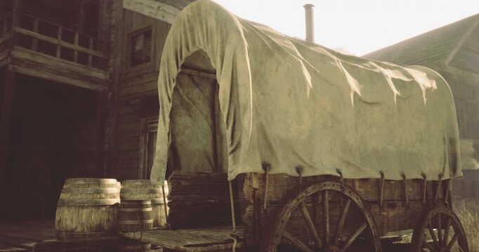 A vintage covered wagon rests beside wooden barrels, showcasing a rustic environment. The warm hues of sunset create a nostalgic atmosphere reminiscent of a bygone era.
