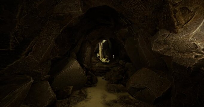 A narrow passage leads deeper into a dimly lit cave, showcasing intricate rock formations. Shadows dance along the walls as a faint light appears in the distance, inviting exploration.