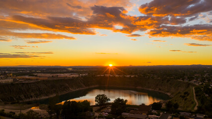 Aerial shot of a lake surrounded by homes and lush green trees at sunset in Duarte California USA © Marcus Jones