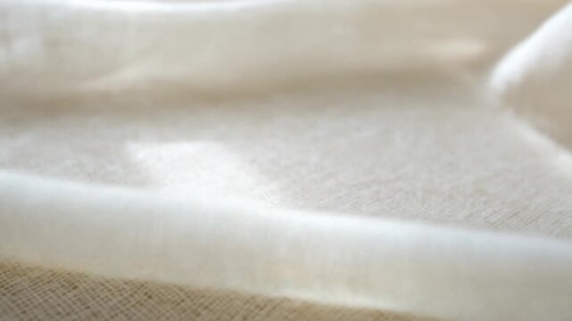Soft cream fabric with gentle folds and subtle texture sunlit curves and smooth fibers in softlight
