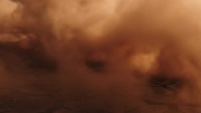 Close-up view of dirt being kicked up, showcasing motion and texture, with a blurred background of nature