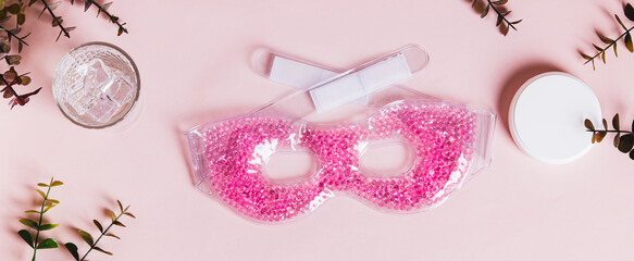 A trendy cryo skincare ice mask gadget on a pink table top view web banner