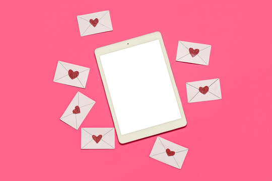 Tablet computer with love letters on pink background. Concept of online dating - Powered by Adobe