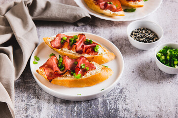 Baked bruschetta with ricotta and bacon on a plate on the table