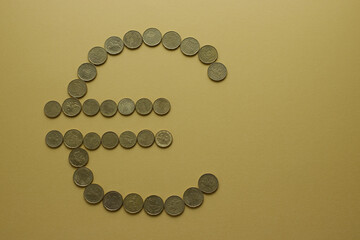 Euro sign formed from coins on a minimalist background