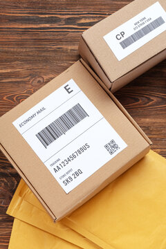 Cardboard packages with labels and barcodes on wooden table