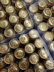 Beer cans. Many golden beer cans in crates, top view