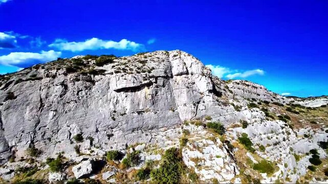 Close proximity FPV flight along a steep, layered roc wall.