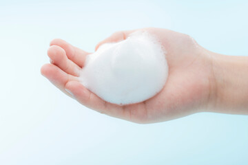 子どもの手に広がるきめ細かな泡を捉えた清潔感あふれるヘルスケアイメージ