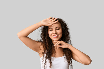 Fototapeta premium Happy young African-American woman with healthy moisturized skin on white background