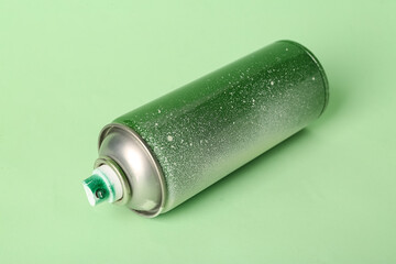 Spray paint can on green background