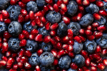 Berry fusion texture. A vibrant mix of blueberries and pomegranate seeds creating a rich red-blue pattern, symbolizing antioxidants, healthy lifestyle, and beautiful natural texture.