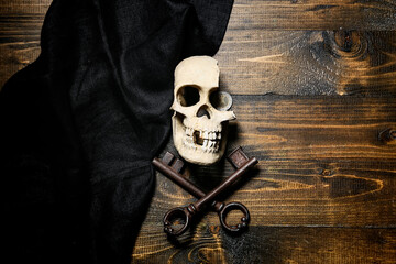 Skull with old keys and black cloth on wooden background. Pirate concept © Pixel-Shot