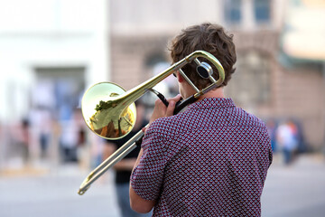 Reflection of the street in the instrument solo trumpet. male musician plays the trombone. music and creativity. jazz and Blues