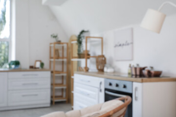 Blurred view of light kitchen with counters and shelf units
