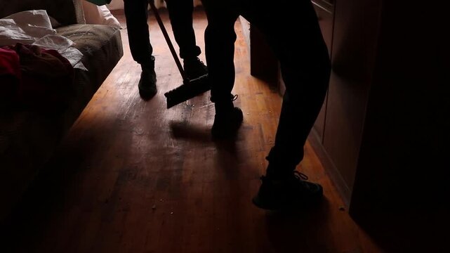 People clean up after a drone exploded near a multi-story building, causing a blast wave that blew out a window and damaged an apartment in Ukraine