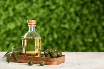Bottle of fresh olive oil on white table outdoors