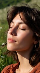 Radiant close-up of a woman with eyes gently closed, her face warmed by midday sun, with a rustic meadow as the backdrop. 
