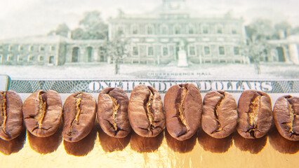 Detailed view of roasted coffee beans atop a U.S. dollar, emphasizing currency elements and a portrait, great for financial and coffee-related projects