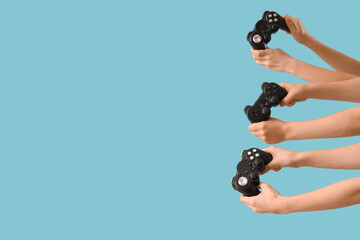 Female hands with game pads on blue background