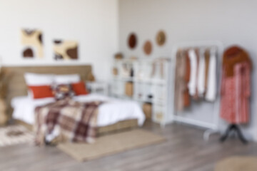 Interior of stylish modern bedroom with clothes rack, shelving unit and mannequin. Blurred view