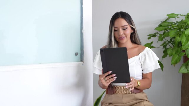 businesswoman with professional face. Latin woman using a tablet in the office - Powered by Adobe