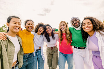 Group of women embracing and sharing joyful smiles. Close friends showing affection and mutual support in a natural moment. Unity and emotional connection concept.