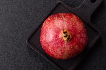 A juicy, ripe, whole red pomegranate as a source of beneficial nutrients. A whole red pomegranate