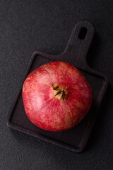 A juicy, ripe, whole red pomegranate as a source of beneficial nutrients. A whole red pomegranate