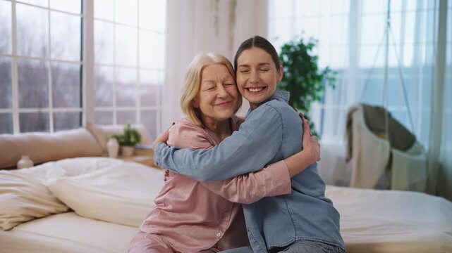 Happy senior female hugging granddaughter in care home, love and support