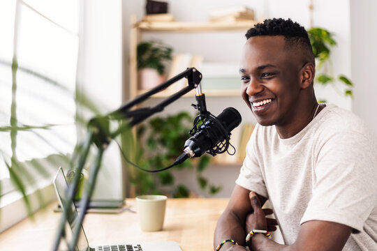 Young African student man recording an online podcast at home. Content creator people concept - Powered by Adobe