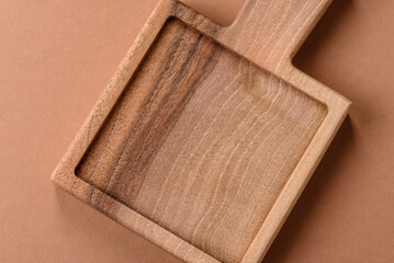 Wood, a wooden empty cutting board on a dark kitchen table. Wooden cutting board