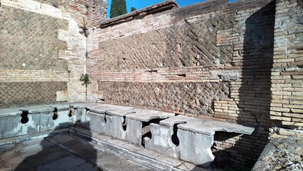 Ostia Antica, Rome - November 30, 2025, public toilets, the public restrooms of the ancient Romans, in the large archaeological park of Ostia Antica.