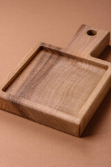 Wood, a wooden empty cutting board on a dark kitchen table. Wooden cutting board
