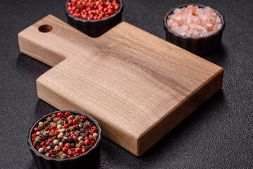 Wood, a wooden empty cutting board on a dark kitchen table. Wooden cutting board