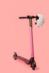 Modern electric scooter with helmet on pink background
