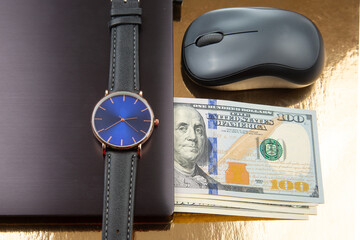 Dollars, wristwatch near laptop with mouse. Business online. Working time for working with laptop.