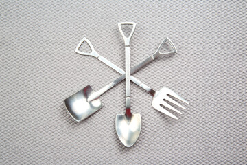 decorative fork and spoons in the form of spades on a gray background. food tools.