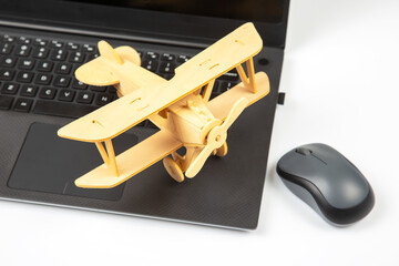 Model of a wooden plane on the background of a laptop. Business development and success. Dream to fly in your favorite business.