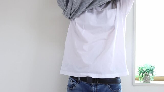 セーターを脱ぐ男性（日本人、顔無し、30代）