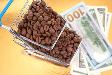 A mini shopping cart brims with coffee beans beside $100 bills on a golden surface, blending commerce and luxury in a striking financial concept