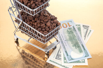 Roasted coffee beans in a small cart with $100 bills on a shiny gold background, symbolizing the high value of coffee in trade and economy.