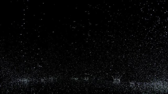 Super Slow Motion Shot of Real Raindrops Falling on a Surface, Isolated on Black, at 1000fps