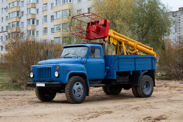 Truck-mounted aerial work platform on retro car. A versatile lifting machine used for construction, maintenance, and tree care operations.