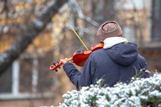 Street musician playing the violin. Musical creativity. Bowed stringed musical instrument