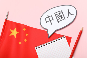 Speech bubble with Chinese text, flag and notebook on pink background
